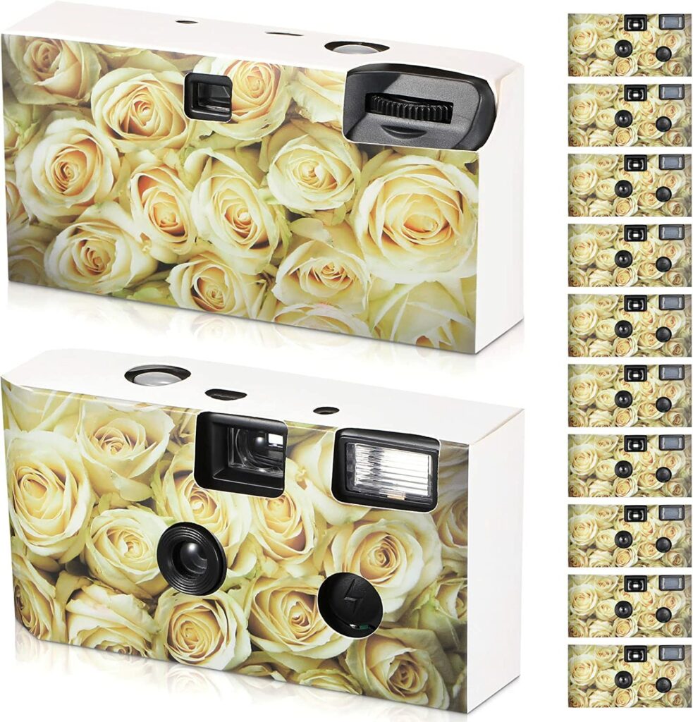 Disposable camera featuring white roses. Images shows front and back of the camera as well as 12 cameras lined up on the side to indicate it's a bulk listing.